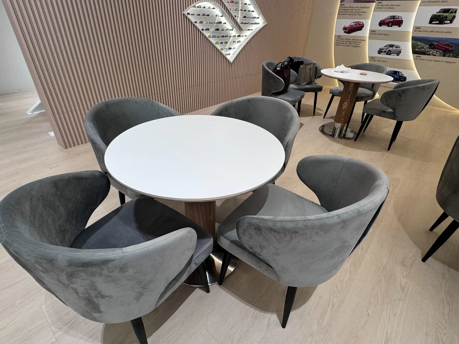 Round consultation table with upholstered visitor chairs in the Suzuki showroom