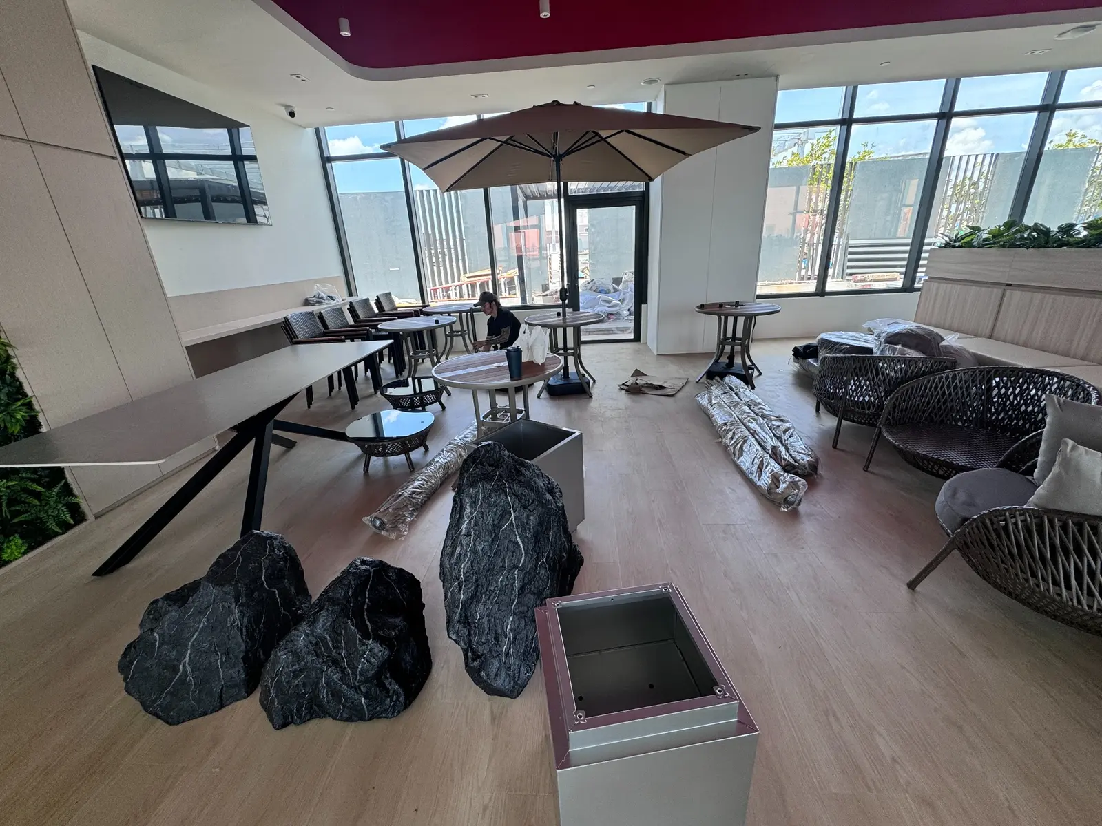 Office collaboration lounge with dining tables, outdoor seating and decorative planters
