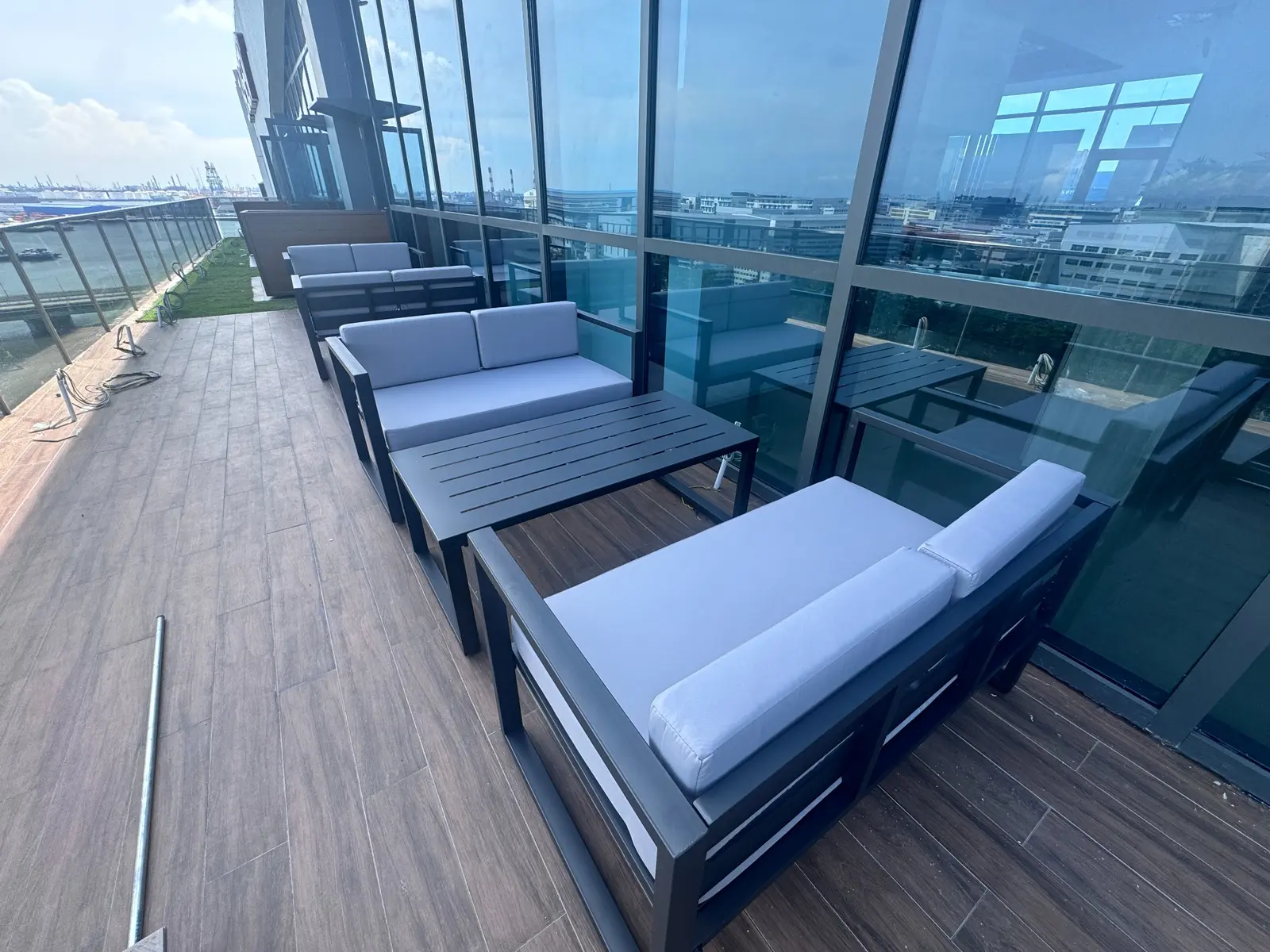 Wide view of an office rooftop terrace furnished with outdoor sofas and a coffee table