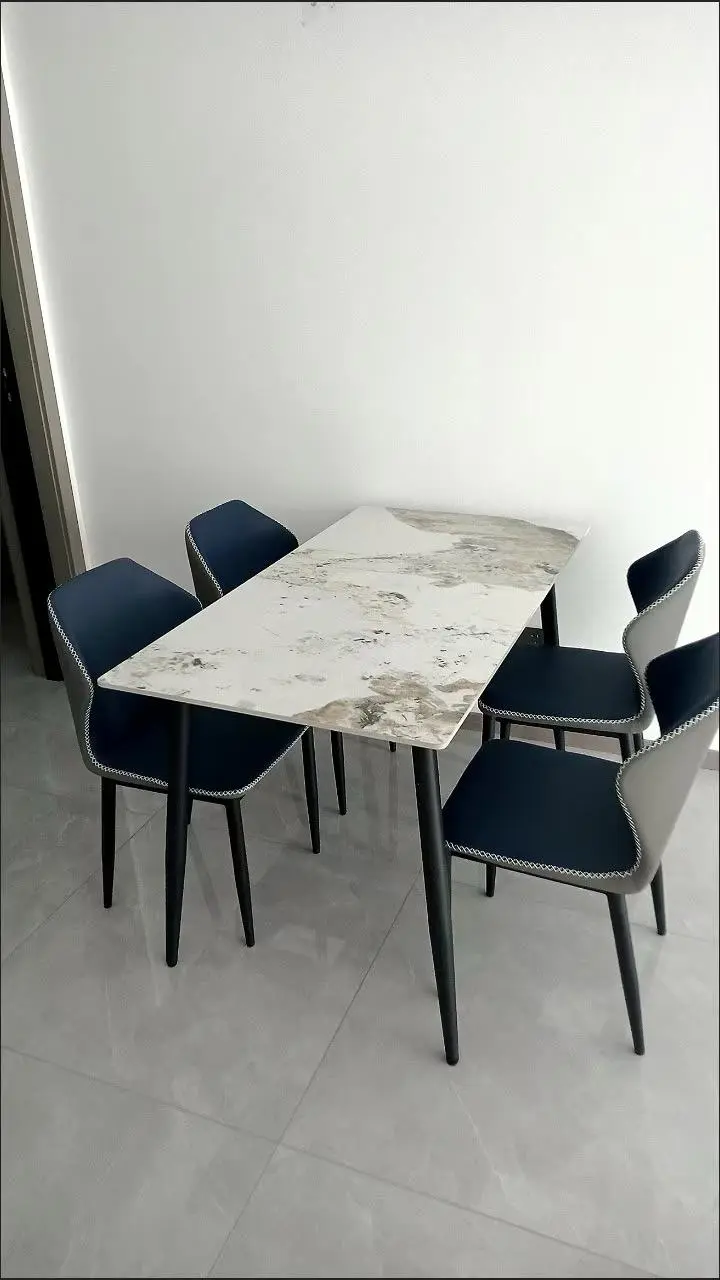 Blue upholstered chairs with a marble-effect dining table