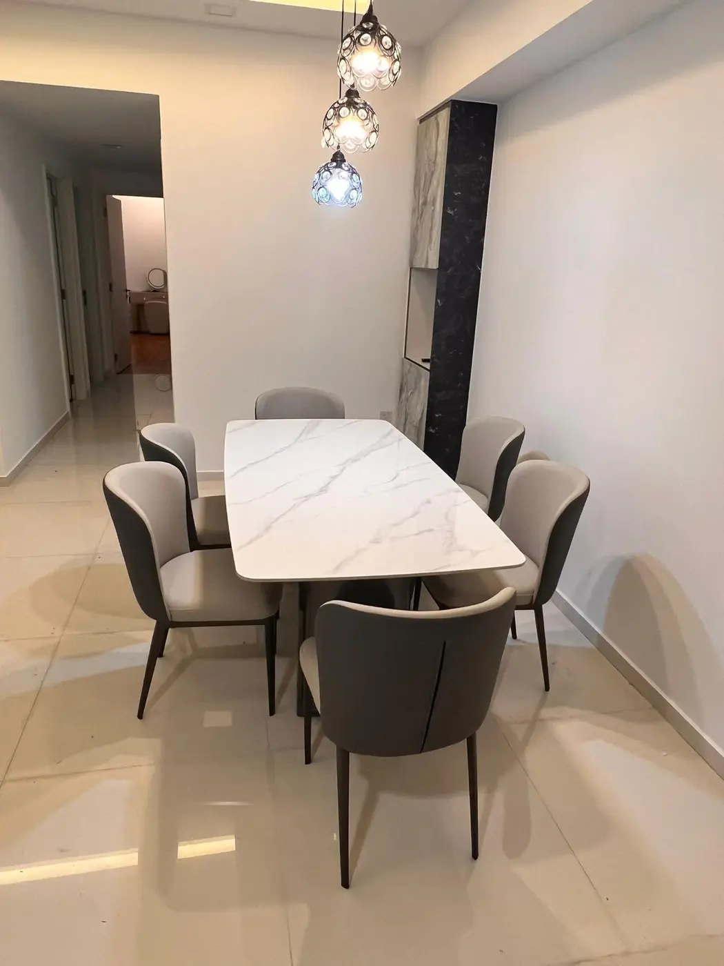 Grey upholstered dining chairs with marble-effect table