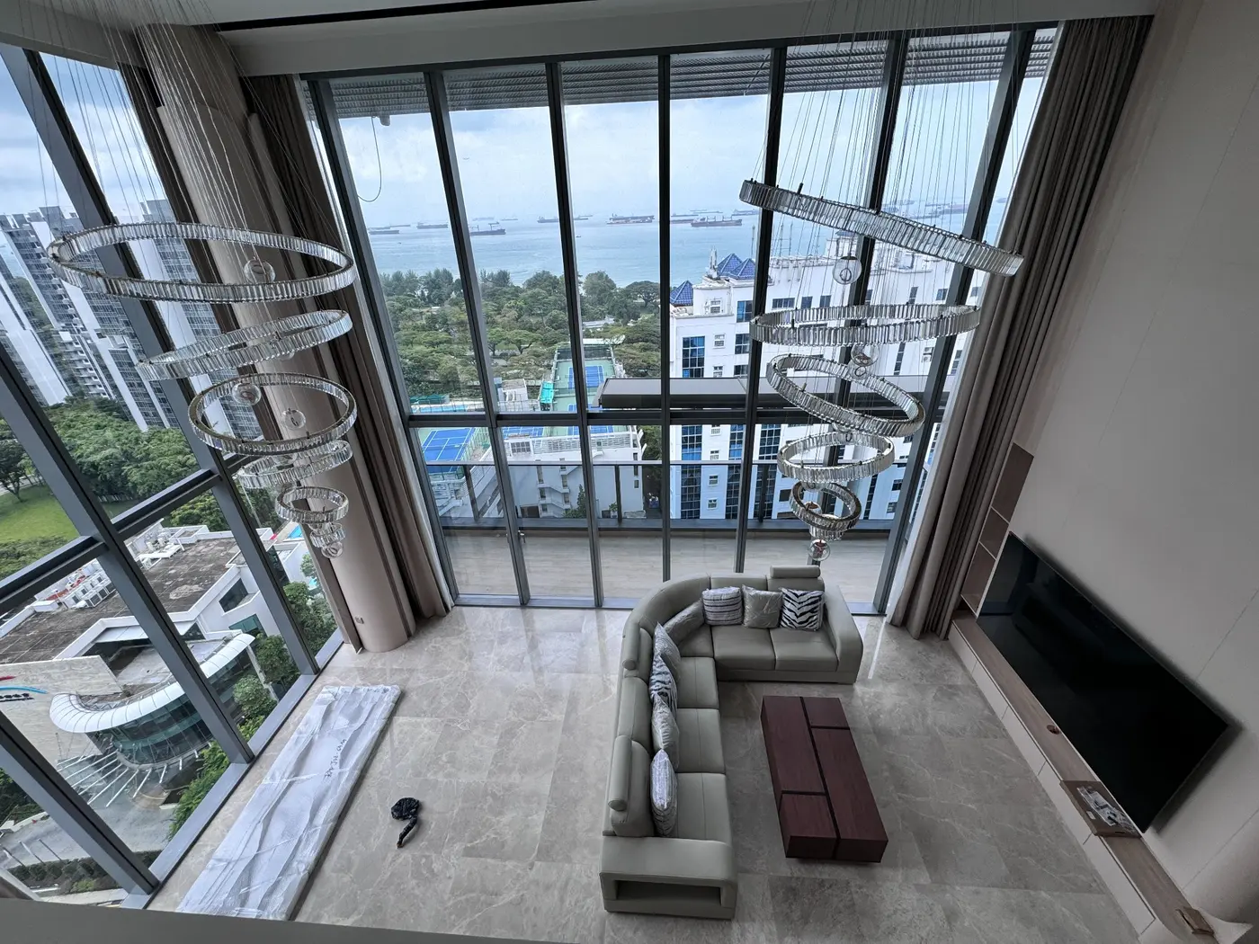 Double-height residential living room with sectional sofa and feature pendant lights