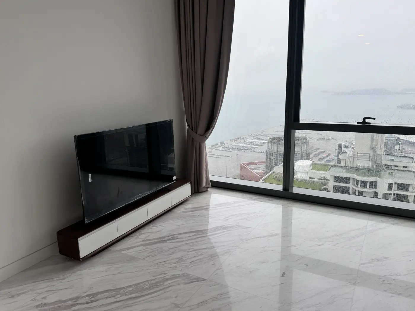 Low television console installed beside full-height windows
