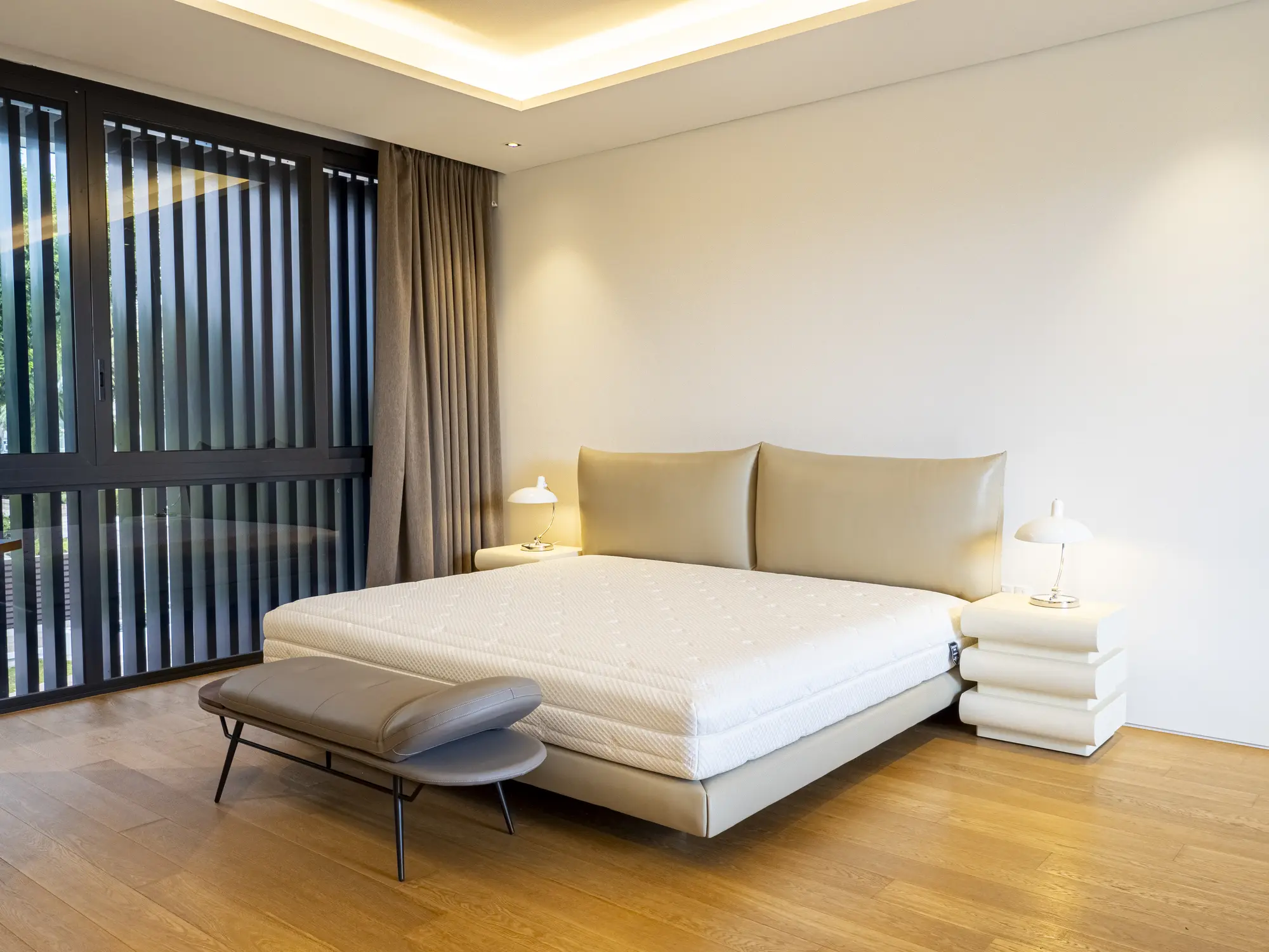 White upholstered bed with timber flooring