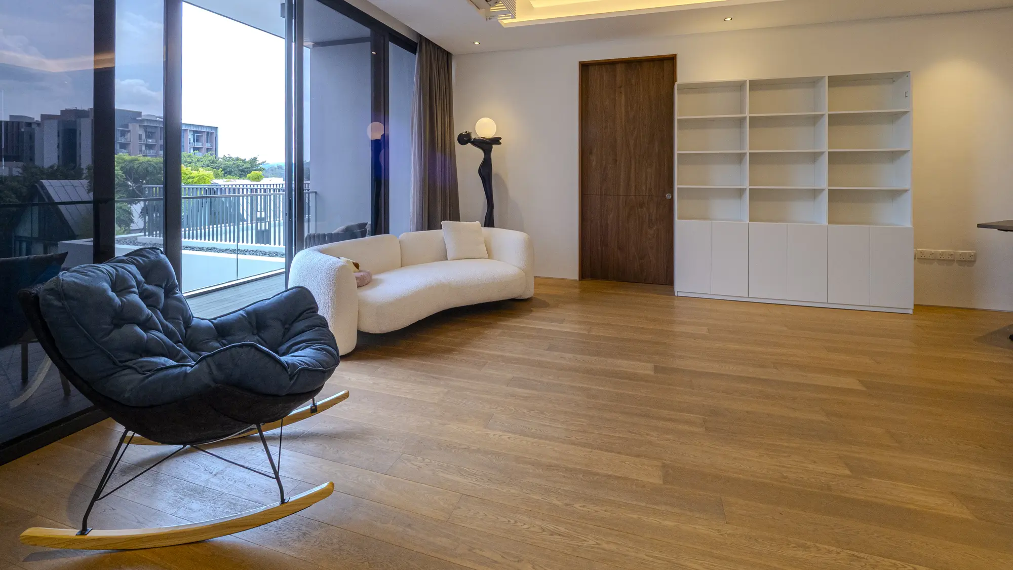 Curved white sofa and black lounge chair beside the windows